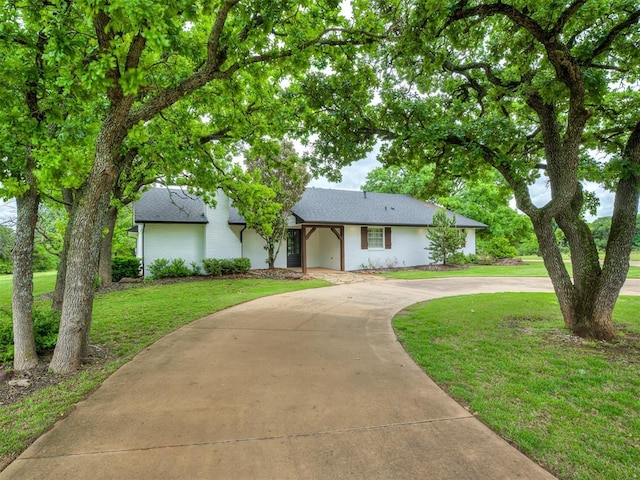400 Carpenter Trl, Arcadia, OK 73007 - single story home featuring curved driveway, brick siding, roof with shingles, and a front yard