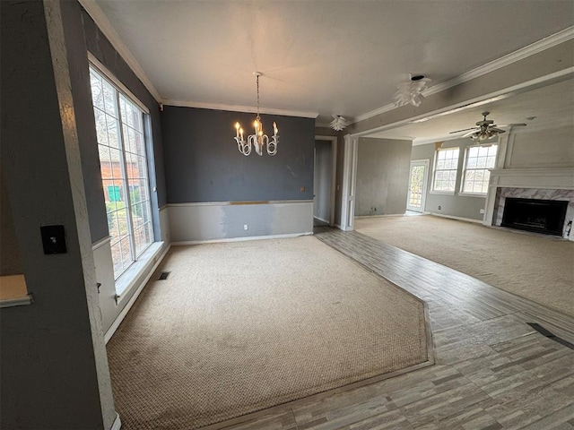 unfurnished living room with a premium fireplace, carpet, visible vents, and ornamental molding