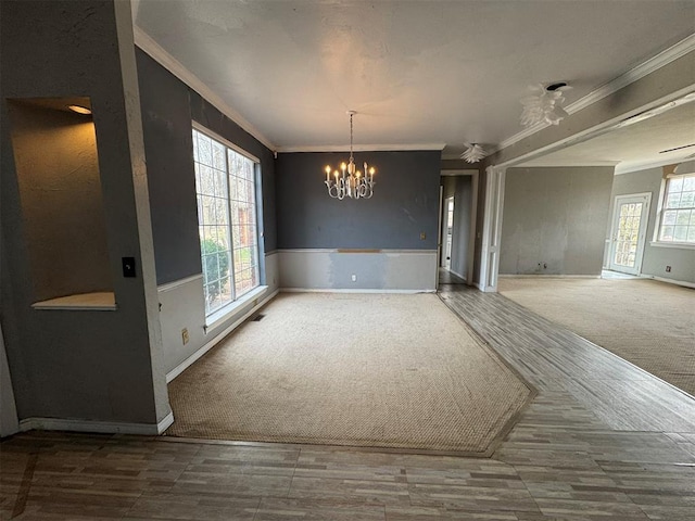 interior space featuring carpet flooring, a notable chandelier, a healthy amount of sunlight, and crown molding