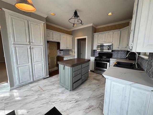 kitchen featuring a sink, a kitchen island, appliances with stainless steel finishes, and white cabinetry