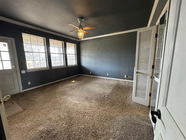 interior space featuring a wealth of natural light, baseboards, carpet floors, and ceiling fan