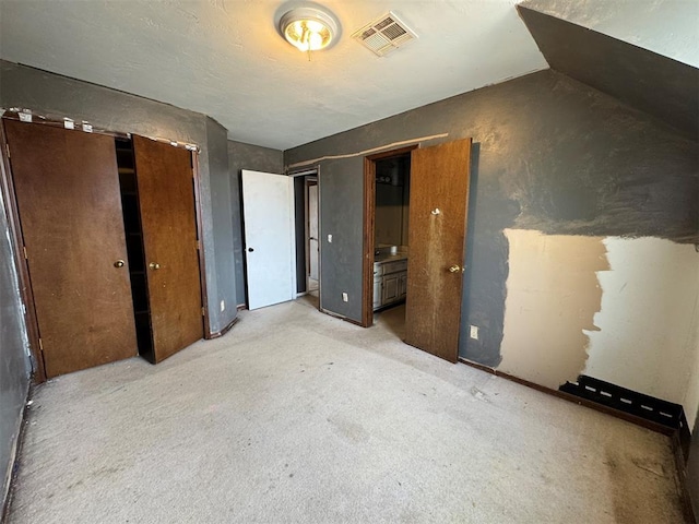 unfurnished bedroom with visible vents and light carpet