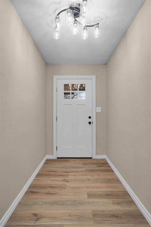 703 Comanche Trl, Altus, OK 73521 - entryway with a chandelier and light wood-style flooring