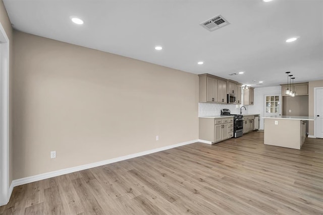 703 Comanche Trl, Altus, OK 73521 - kitchen with stainless steel appliances, light countertops, light wood-type flooring, recessed lighting, and decorative light fixtures