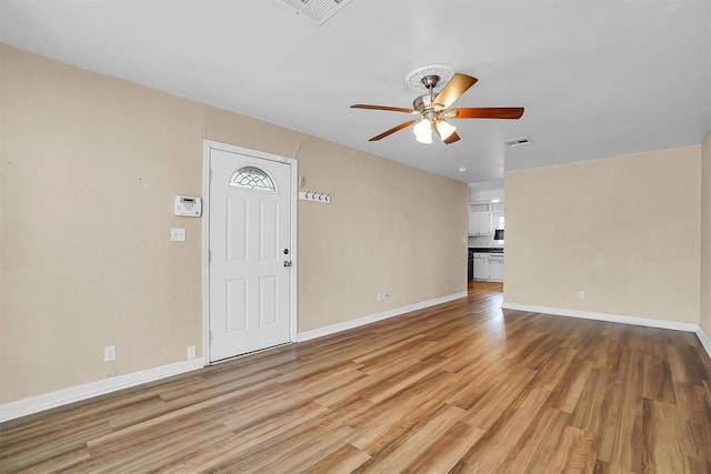 unfurnished living room featuring light wood-type flooring, visible vents, baseboards, and ceiling fan