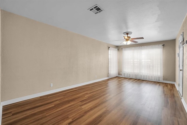 spare room with visible vents, baseboards, a ceiling fan, and wood finished floors