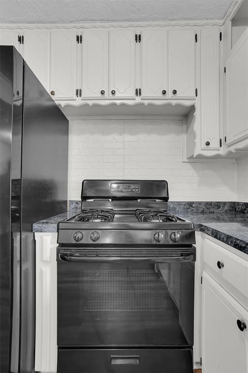 kitchen featuring black appliances, white cabinets, dark countertops, and backsplash