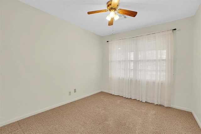 carpeted spare room featuring a ceiling fan and baseboards