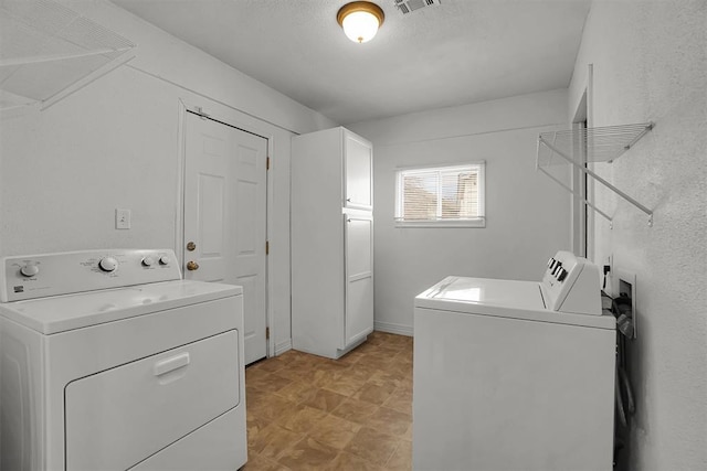 clothes washing area featuring laundry area, visible vents, and washing machine and clothes dryer