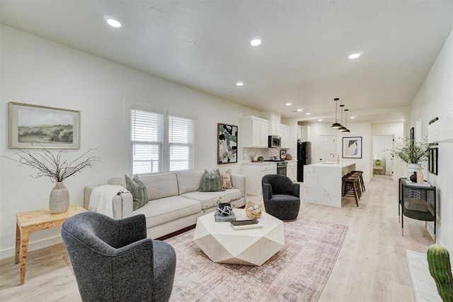 living area featuring recessed lighting, light wood-type flooring, and baseboards