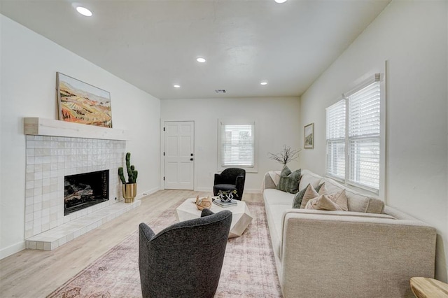 living area featuring recessed lighting, visible vents, wood finished floors, and a fireplace