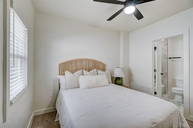 bedroom featuring baseboards, a ceiling fan, wood finished floors, and ensuite bathroom