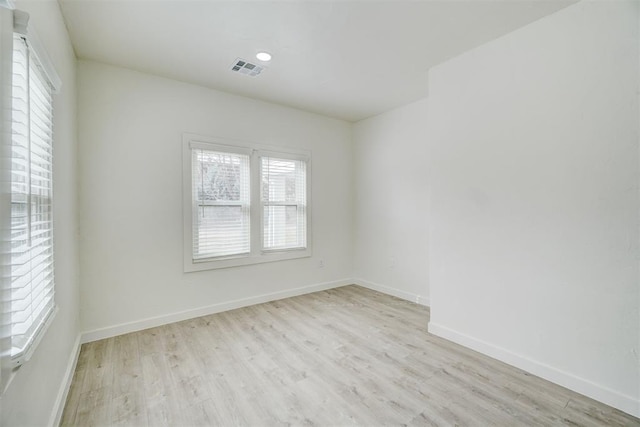 unfurnished room with visible vents, baseboards, and wood finished floors