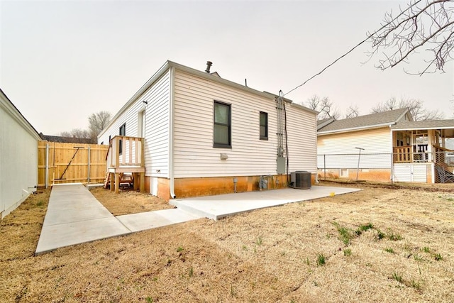 back of property with central air condition unit, a patio, and fence