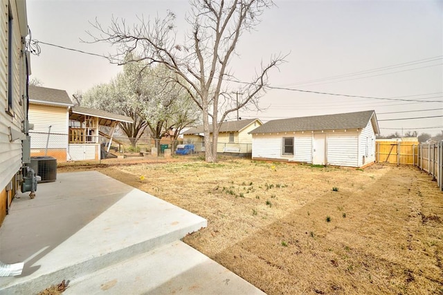 view of yard with an outbuilding, central AC, a fenced backyard, and a patio area