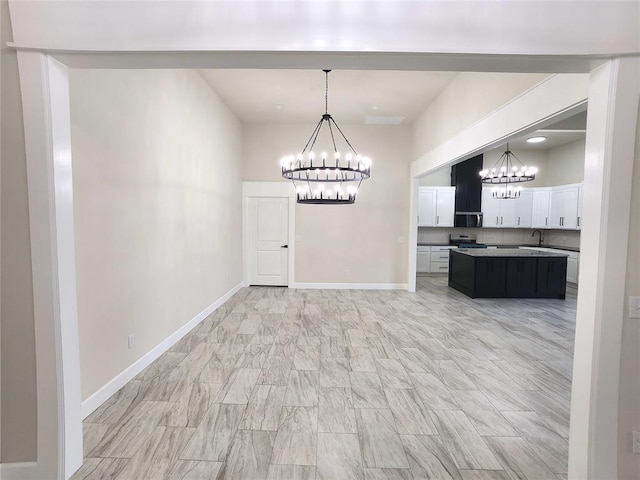 11613 NW 103rd St, Yukon, OK 73099 - unfurnished dining area featuring a chandelier, a sink, and baseboards
