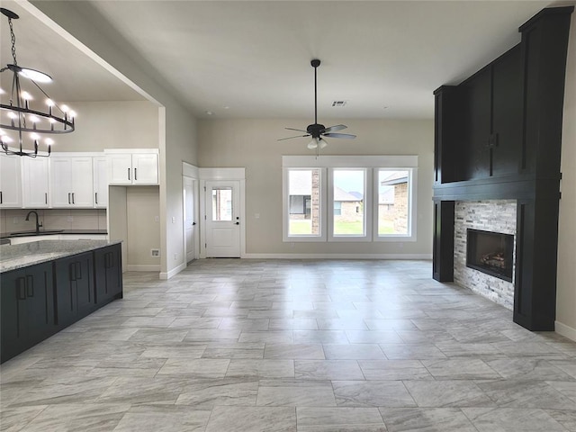 11613 NW 103rd St, Yukon, OK 73099 - kitchen with a sink, a chandelier, open floor plan, light stone countertops, and a ceiling fan