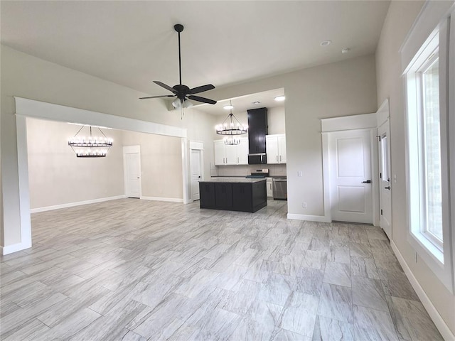 11613 NW 103rd St, Yukon, OK 73099 - unfurnished living room featuring a chandelier, ceiling fan, and baseboards