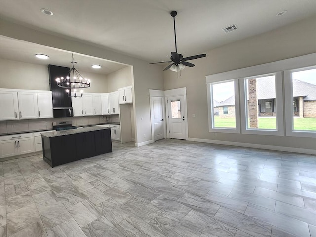 11613 NW 103rd St, Yukon, OK 73099 - kitchen with stainless steel range with electric stovetop, ceiling fan, a sink, a kitchen island, and white cabinetry