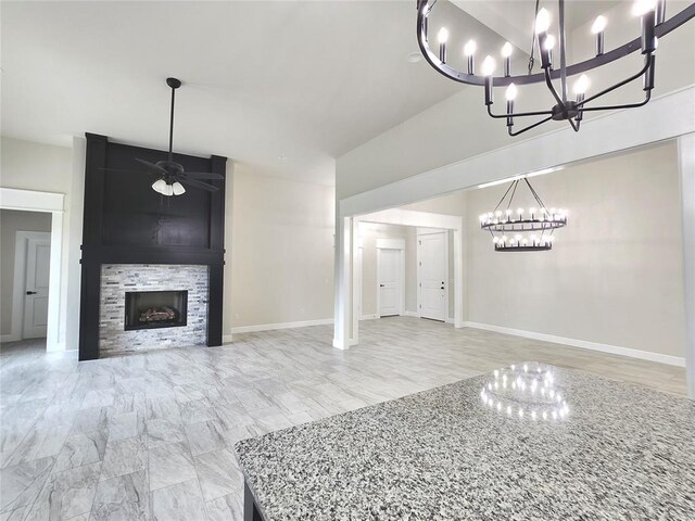 11613 NW 103rd St, Yukon, OK 73099 - unfurnished living room with a chandelier, a ceiling fan, a large fireplace, baseboards, and high vaulted ceiling