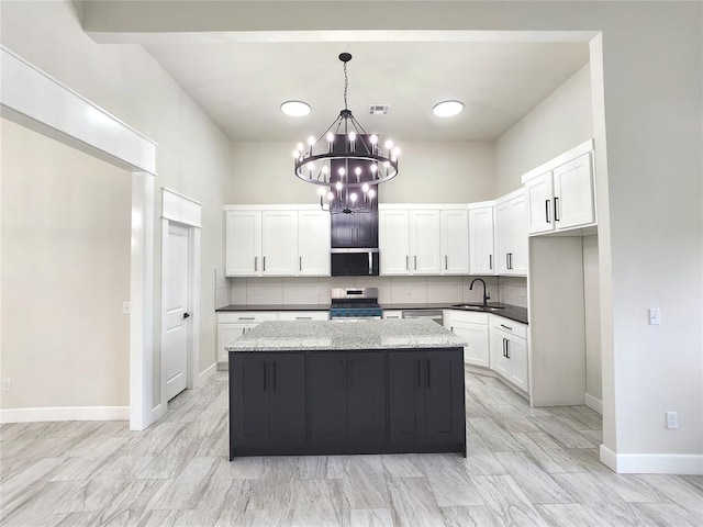 11613 NW 103rd St, Yukon, OK 73099 - kitchen with appliances with stainless steel finishes, a chandelier, a sink, and backsplash