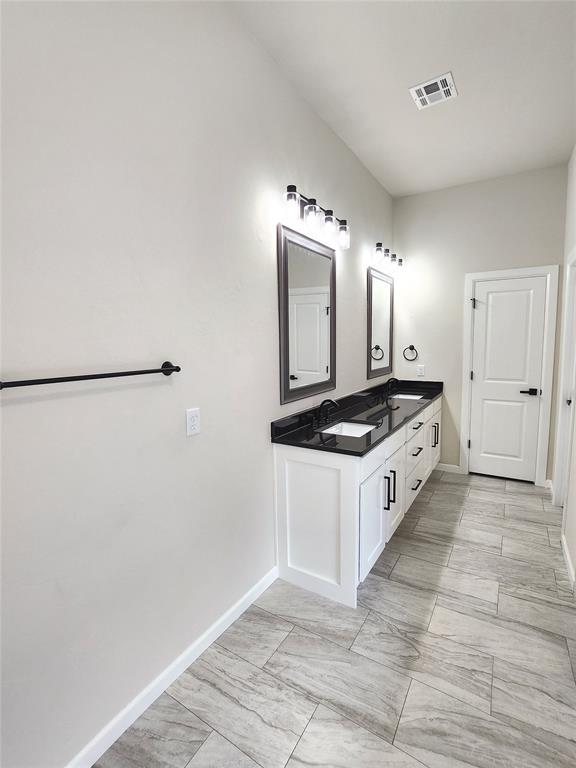 11613 NW 103rd St, Yukon, OK 73099 - full bathroom featuring double vanity and baseboards