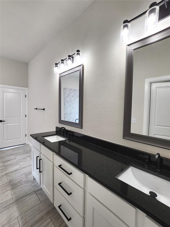 11613 NW 103rd St, Yukon, OK 73099 - bathroom featuring double vanity and wood finished floors