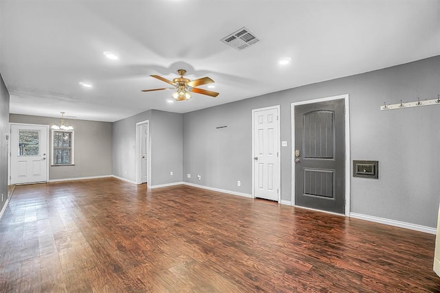 1724 N Lee St, Altus, OK 73521 - unfurnished living room featuring visible vents, baseboards, wood finished floors, and ceiling fan with notable chandelier