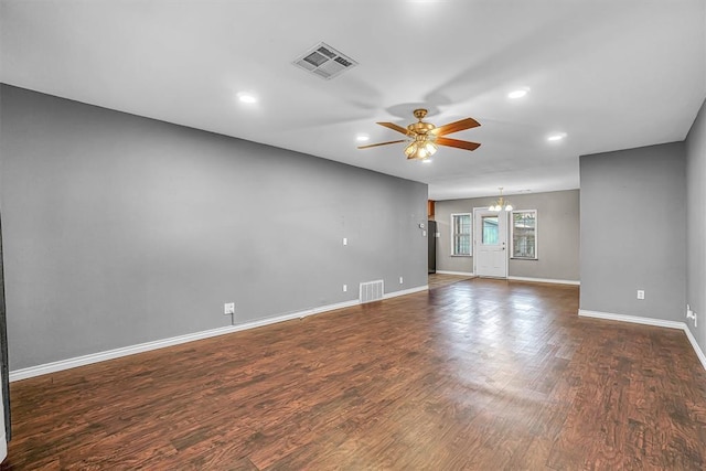 1724 N Lee St, Altus, OK 73521 - empty room featuring visible vents, baseboards, dark wood-style floors, and ceiling fan with notable chandelier