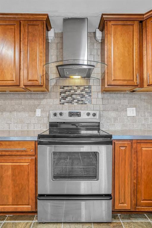 1724 N Lee St, Altus, OK 73521 - kitchen with decorative backsplash, stainless steel range with electric stovetop, brown cabinetry, and wall chimney range hood