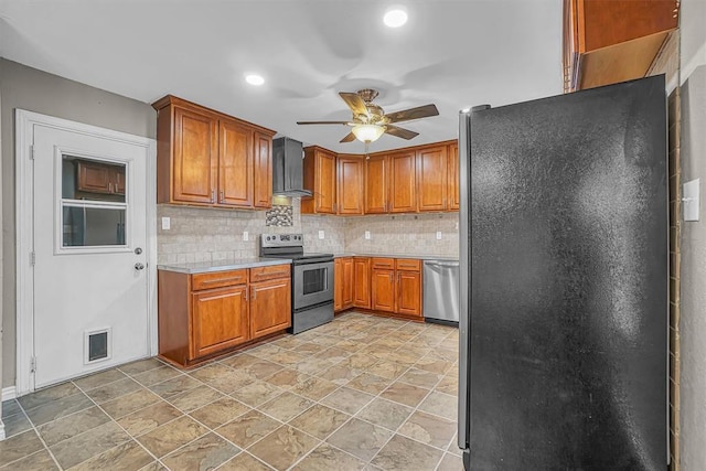 1724 N Lee St, Altus, OK 73521 - kitchen featuring ceiling fan, light countertops, appliances with stainless steel finishes, brown cabinetry, and wall chimney exhaust hood