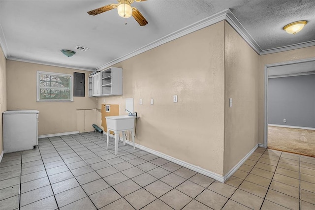 1724 N Lee St, Altus, OK 73521 - kitchen with light tile patterned floors, a ceiling fan, electric panel, ornamental molding, and fridge