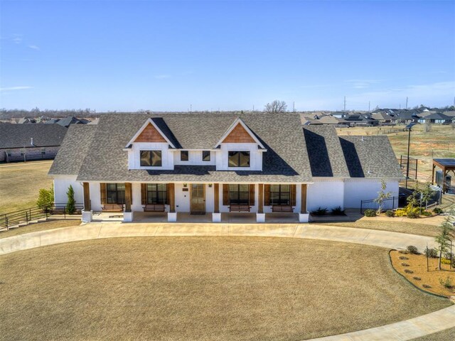 16304 Steppe Dr, Oklahoma City, OK 73170 - modern farmhouse style home featuring roof with shingles, covered porch, and curved driveway