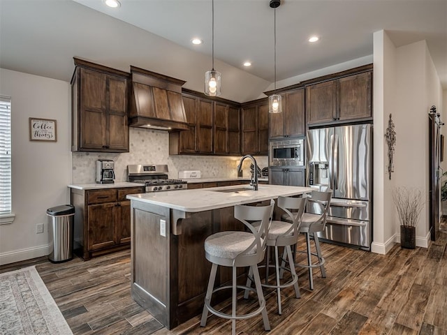 16304 Steppe Dr, Oklahoma City, OK 73170 - kitchen featuring appliances with stainless steel finishes, custom exhaust hood, dark brown cabinets, a sink, and baseboards