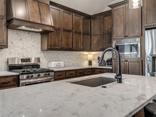 16304 Steppe Dr, Oklahoma City, OK 73170 - kitchen featuring appliances with stainless steel finishes, custom exhaust hood, a sink, backsplash, and light stone countertops