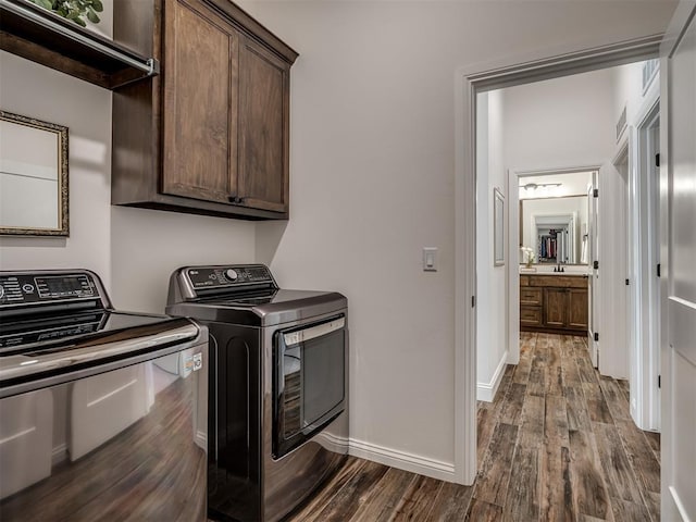 16304 Steppe Dr, Oklahoma City, OK 73170 - laundry room with cabinet space, separate washer and dryer, dark wood finished floors, and baseboards