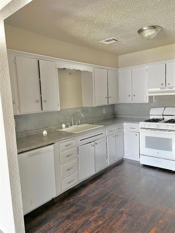 2513 N Nottingham Way, Moore, OK 73160 - kitchen featuring white appliances, a sink, light countertops, dark wood-style floors, and a textured ceiling