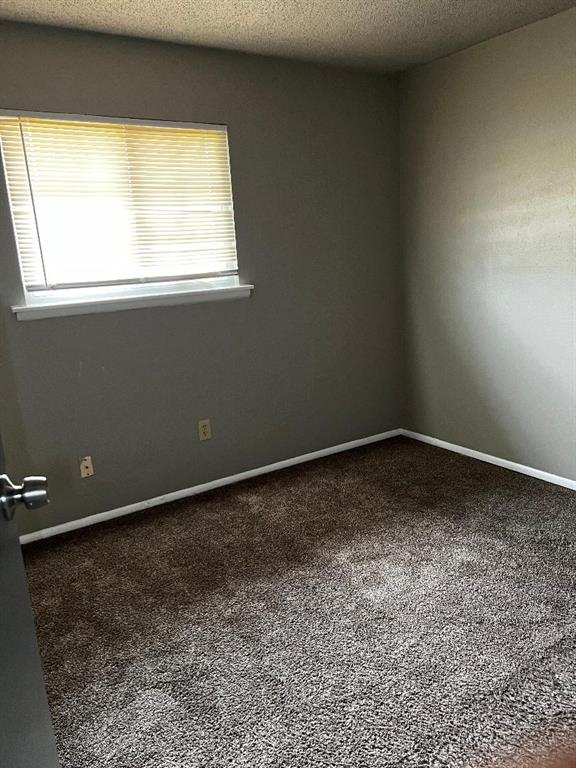 2513 N Nottingham Way, Moore, OK 73160 - carpeted spare room with baseboards and a textured ceiling