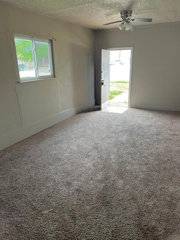 2513 N Nottingham Way, Moore, OK 73160 - spare room with a textured ceiling, a ceiling fan, and carpet
