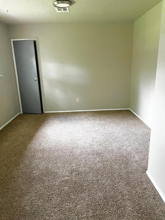 2513 N Nottingham Way, Moore, OK 73160 - carpeted spare room with a textured ceiling and baseboards