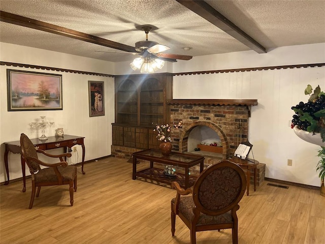 2416 SW 92nd St, Oklahoma City, OK 73159 - living room with beam ceiling, light wood-style floors, ceiling fan, and a textured ceiling