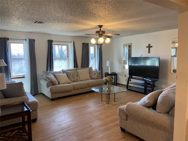 2416 SW 92nd St, Oklahoma City, OK 73159 - living room with a ceiling fan, plenty of natural light, light wood-style floors, and a textured ceiling