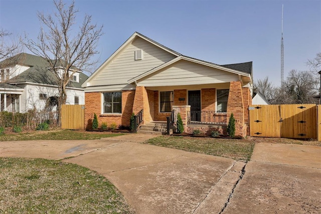 1721 NW 35th St, Oklahoma City, OK 73118 - view of front of property featuring a porch, a gate, fence, and brick siding