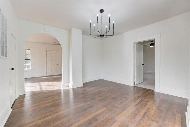 1721 NW 35th St, Oklahoma City, OK 73118 - unfurnished room featuring ceiling fan with notable chandelier, wood finished floors, arched walkways, and baseboards