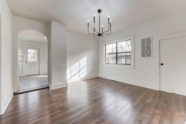 1721 NW 35th St, Oklahoma City, OK 73118 - unfurnished dining area featuring arched walkways, a notable chandelier, plenty of natural light, and wood finished floors