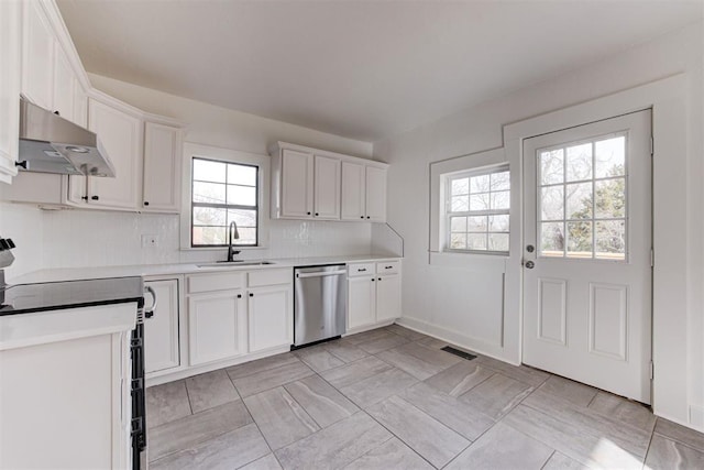 1721 NW 35th St, Oklahoma City, OK 73118 - kitchen with visible vents, under cabinet range hood, dishwasher, light countertops, and a sink