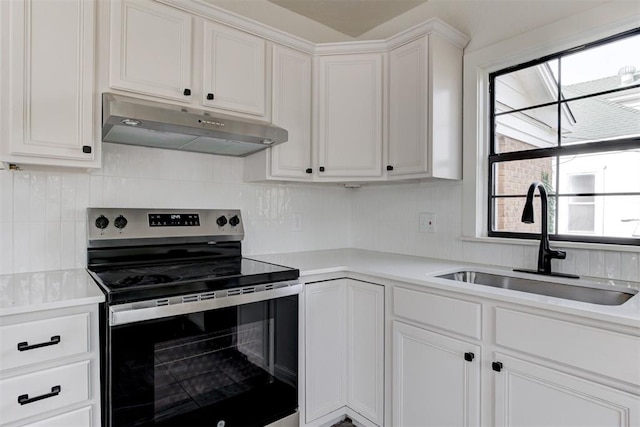 1721 NW 35th St, Oklahoma City, OK 73118 - kitchen with a sink, tasteful backsplash, under cabinet range hood, and stainless steel range with electric cooktop