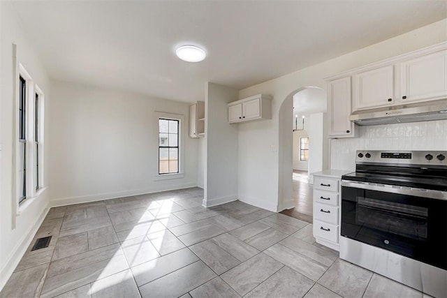 1721 NW 35th St, Oklahoma City, OK 73118 - kitchen featuring visible vents, backsplash, under cabinet range hood, electric stove, and arched walkways