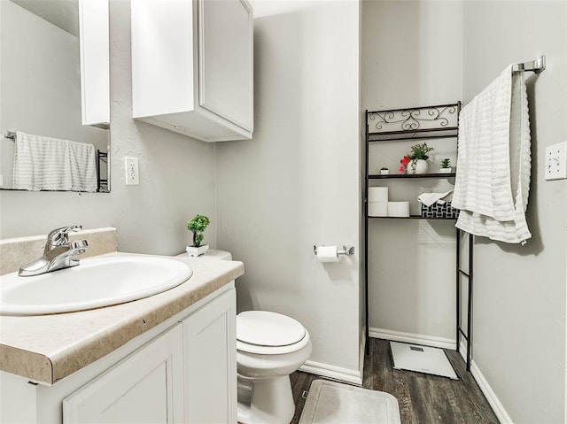 1415 NW 98th St, Oklahoma City, OK 73114 - bathroom with baseboards, toilet, wood finished floors, and vanity