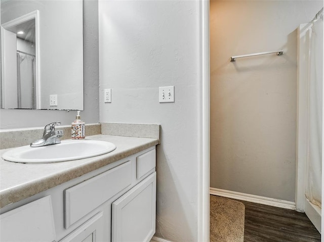 1415 NW 98th St, Oklahoma City, OK 73114 - full bathroom with baseboards, wood finished floors, and vanity